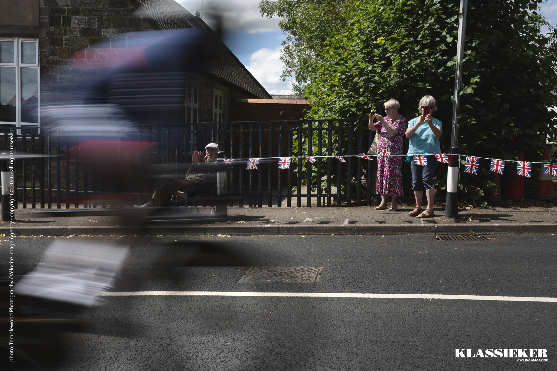 Birmingham 2022 - A man and two women watch the time trial as a rider speeds by