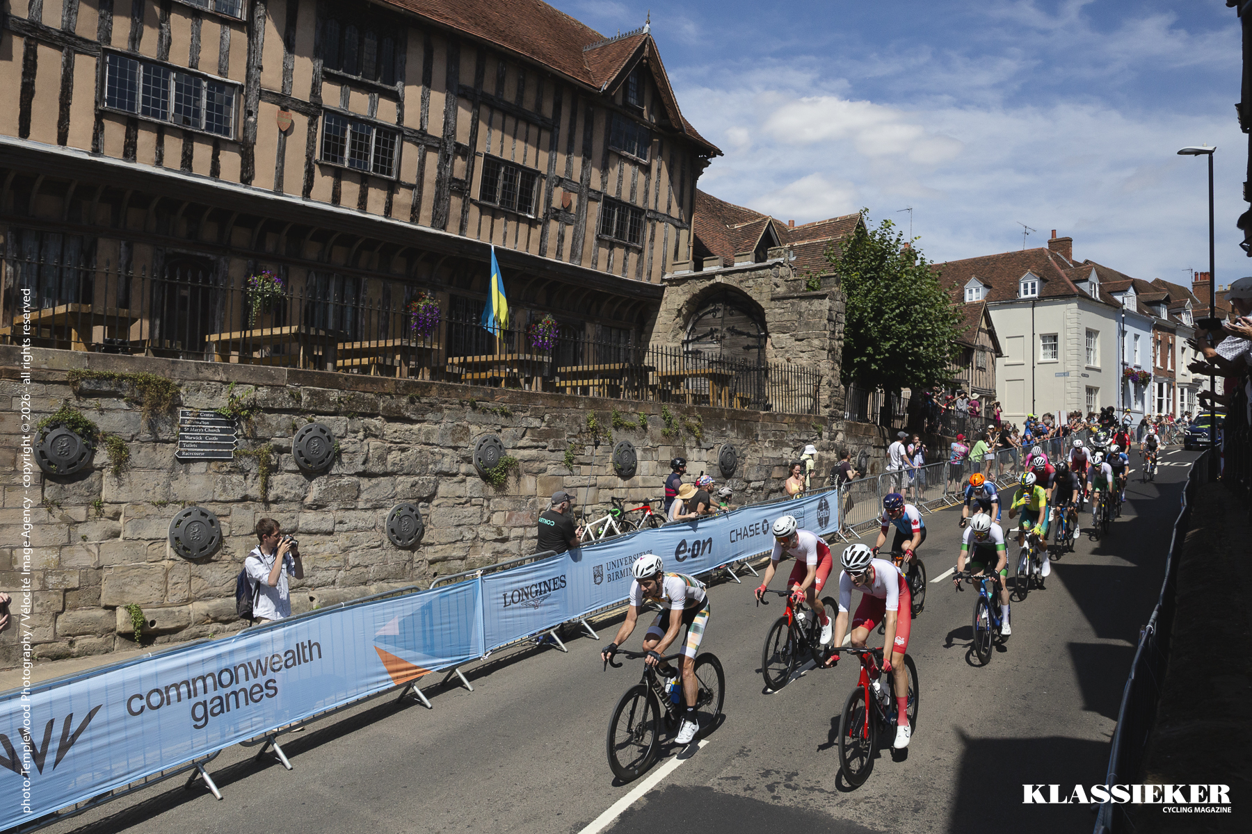 Birmingham 2022 - Riders pass the historic backdrop of Warwick