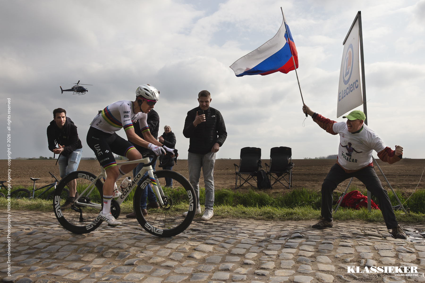 Paris Roubaix 2025 - Tadej Pogačar is encouraged by an enthusiastic flag waving fan during the race on the Carrefour De L’Arbre sector