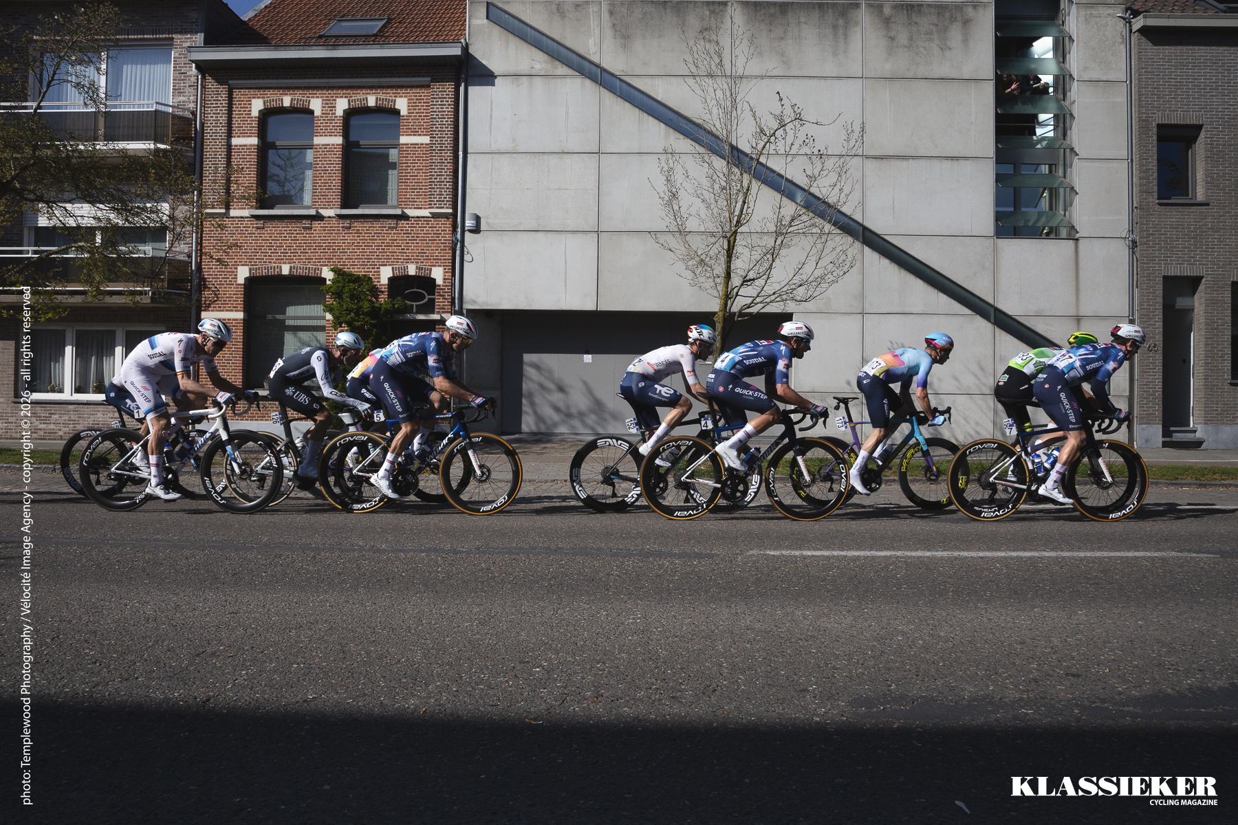 Scheldeprijs 2025 - An elite group of riders race past the brutalist frontage of a modern house in Schoten