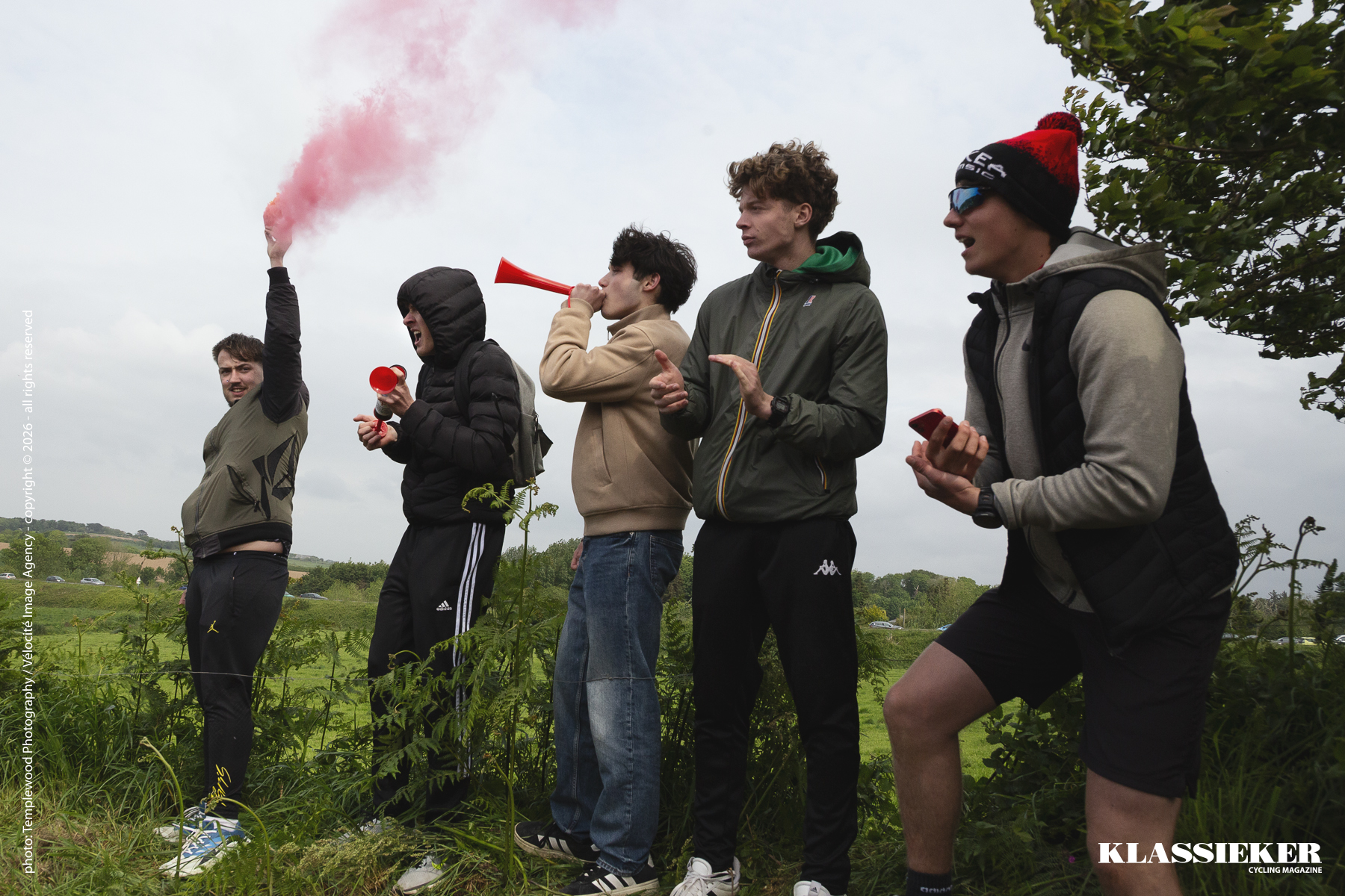 Tro Bro Leon 2026 - Fans, one holding a flare, cheer the riders on