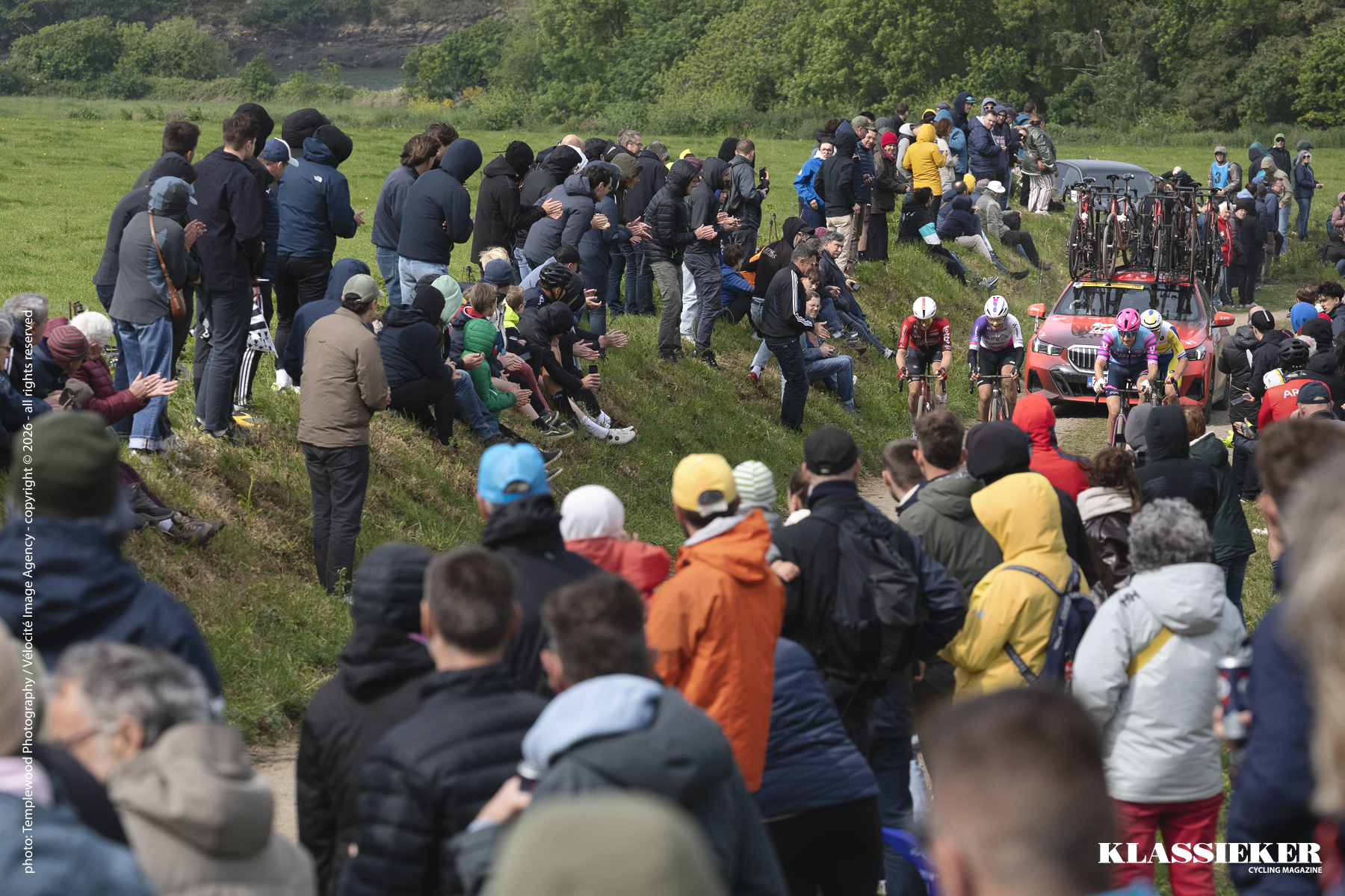 Tro Bro Leon 2026 - Riders can be seen ascending through the crowd with a team car behind them carrying spare bikes