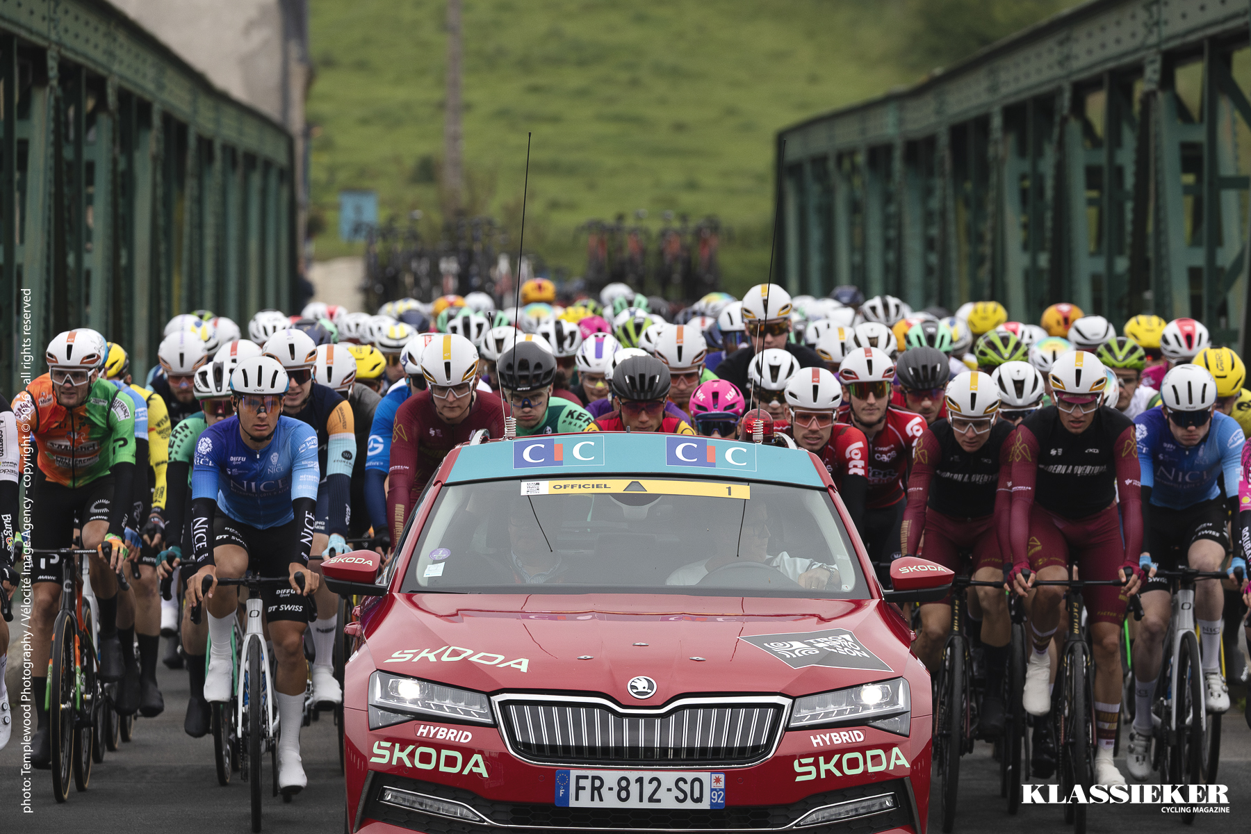 Tro Bro Leon 2026 - The red Race Director’s car leads the peloton over a bridge during the neutralised start